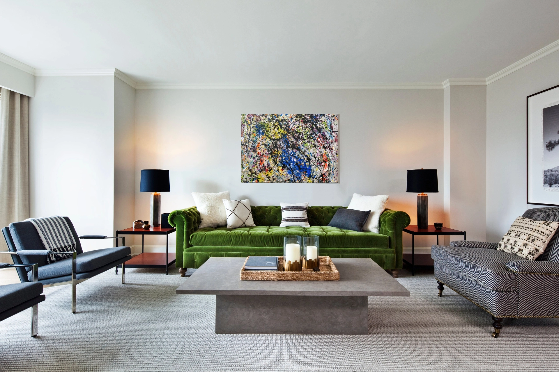 Classic living room with a green velvet sofa, abstract art, and matching black shade lamps