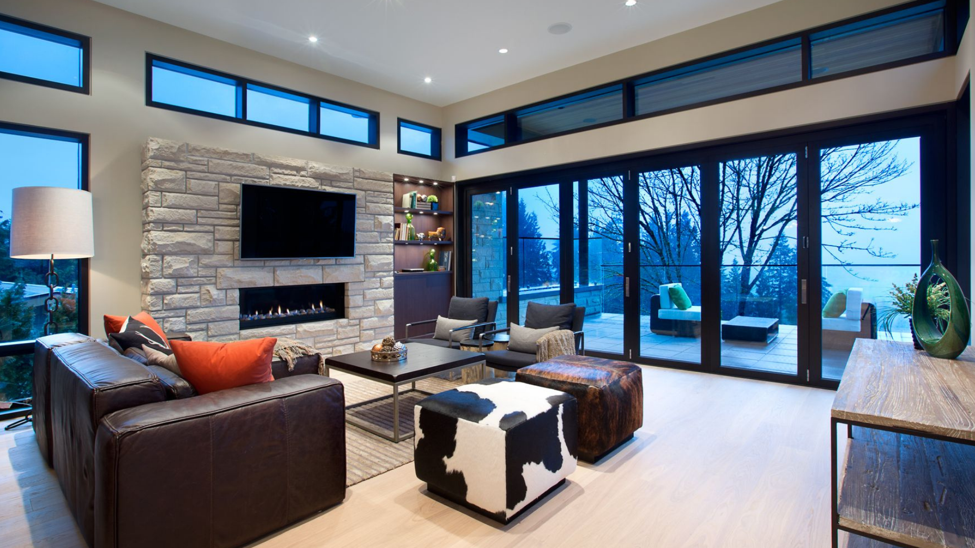 Modern living room with stone fireplace and floor-to-ceiling windows