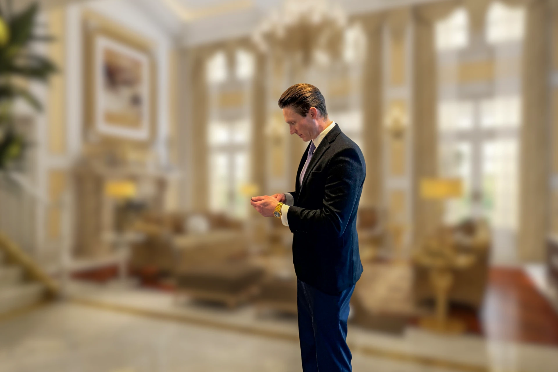 Mike Wilen checking his watch in a light-filled formal living room