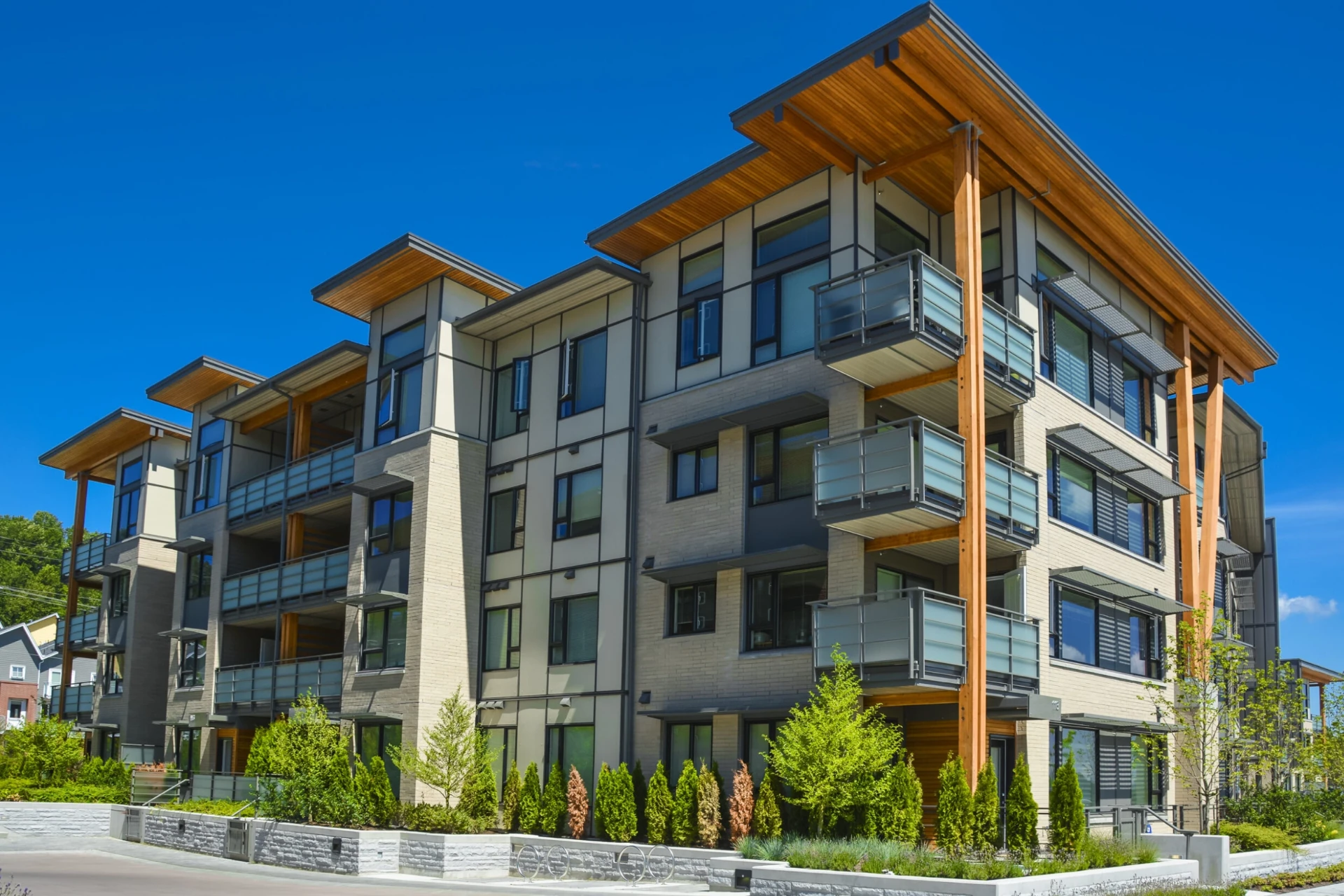 Modern four-story mixed-use commercial building with timber accents and glass balconies